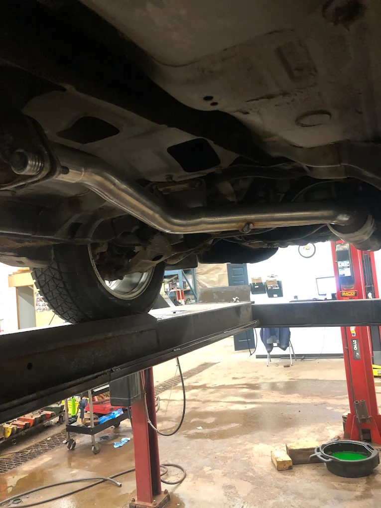 Vehicle raised on the hoist at Pete's Muffler with the underside, wheels and brake assemblies accessible for inspection
