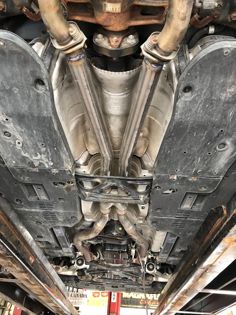 Underside of a vehicle on the hoist showing steering and suspension components