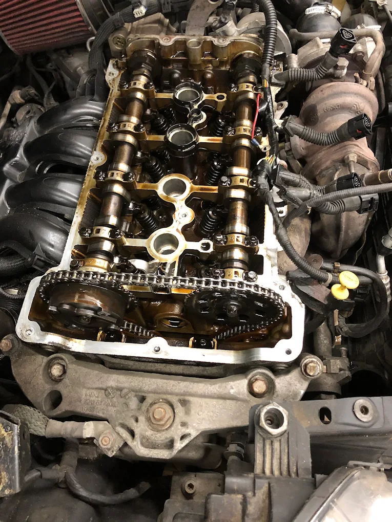 Engine opened up showing camshafts and timing chain during diagnostic work at Pete's Muffler