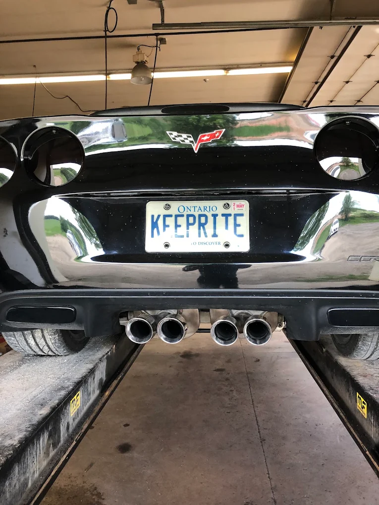 Chevrolet Corvette C6 with four polished exhaust tips seen from behind on the lift